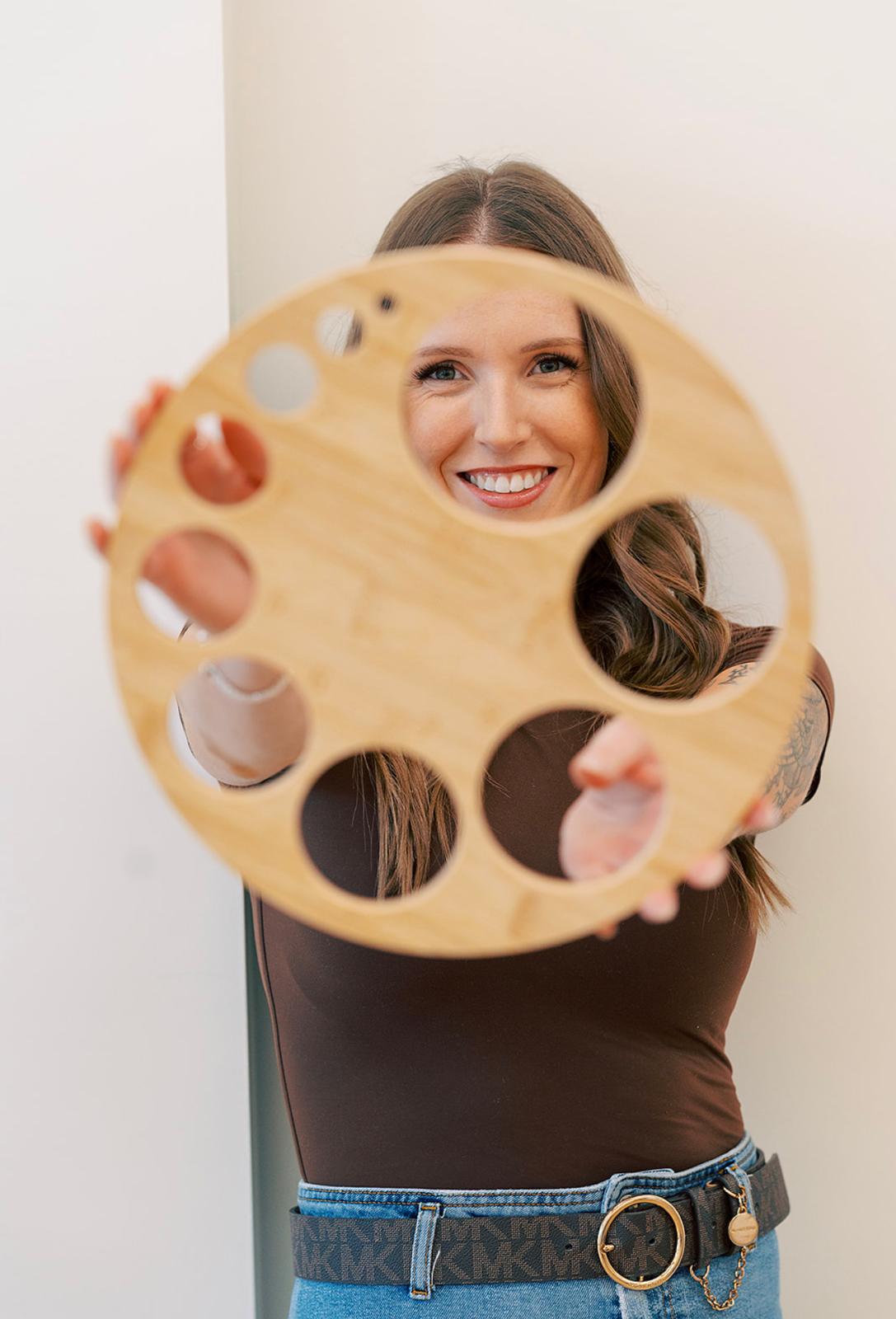Danita holding up a wooden dilation chart